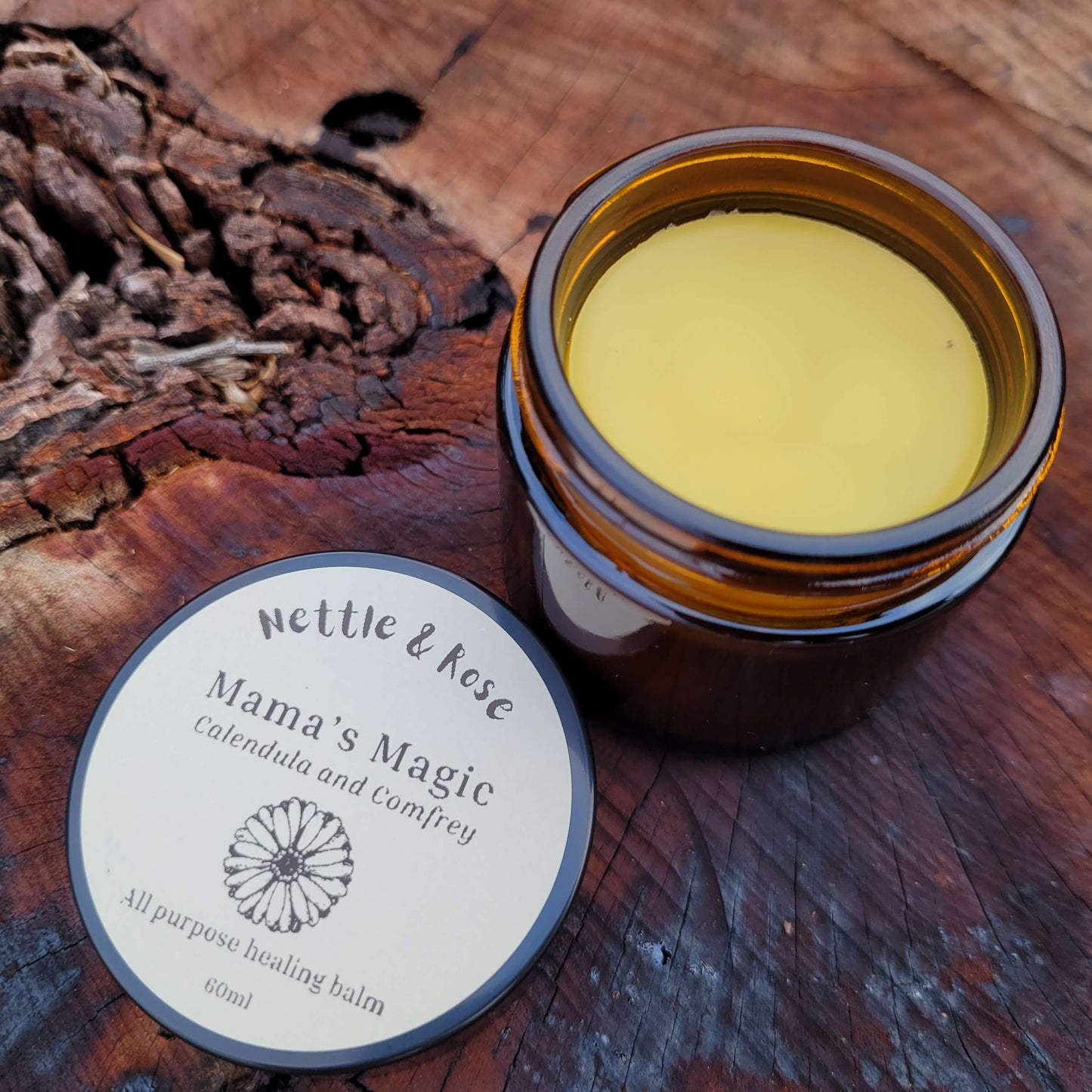 Jar of Mama's Magic balm on a wooden surface with a label
