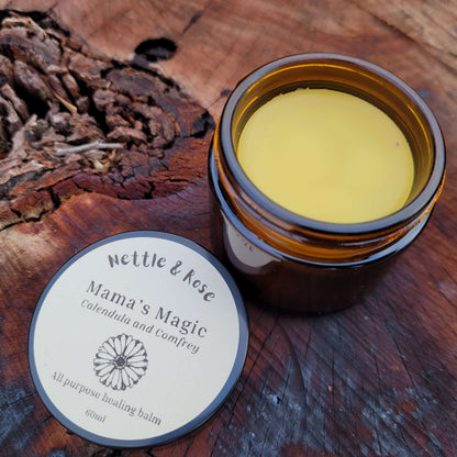 Jar of Mama's Magic balm on a wooden surface with a label